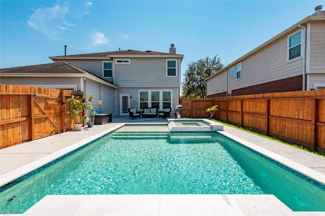 a view of an house with backyard and a tree