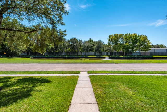 a view of swimming pool with seating area and trees in the background