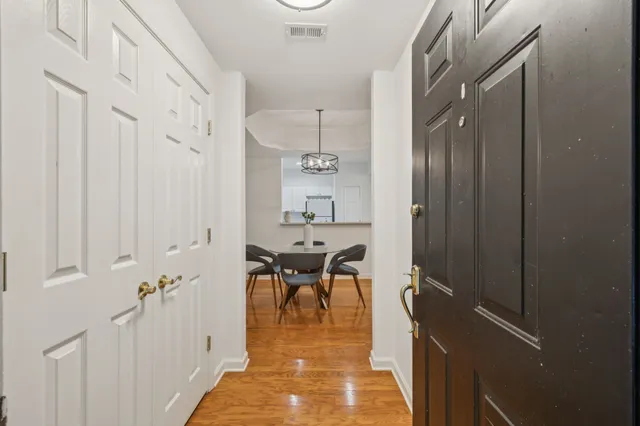 a view of a hallway with a dining table and chairs