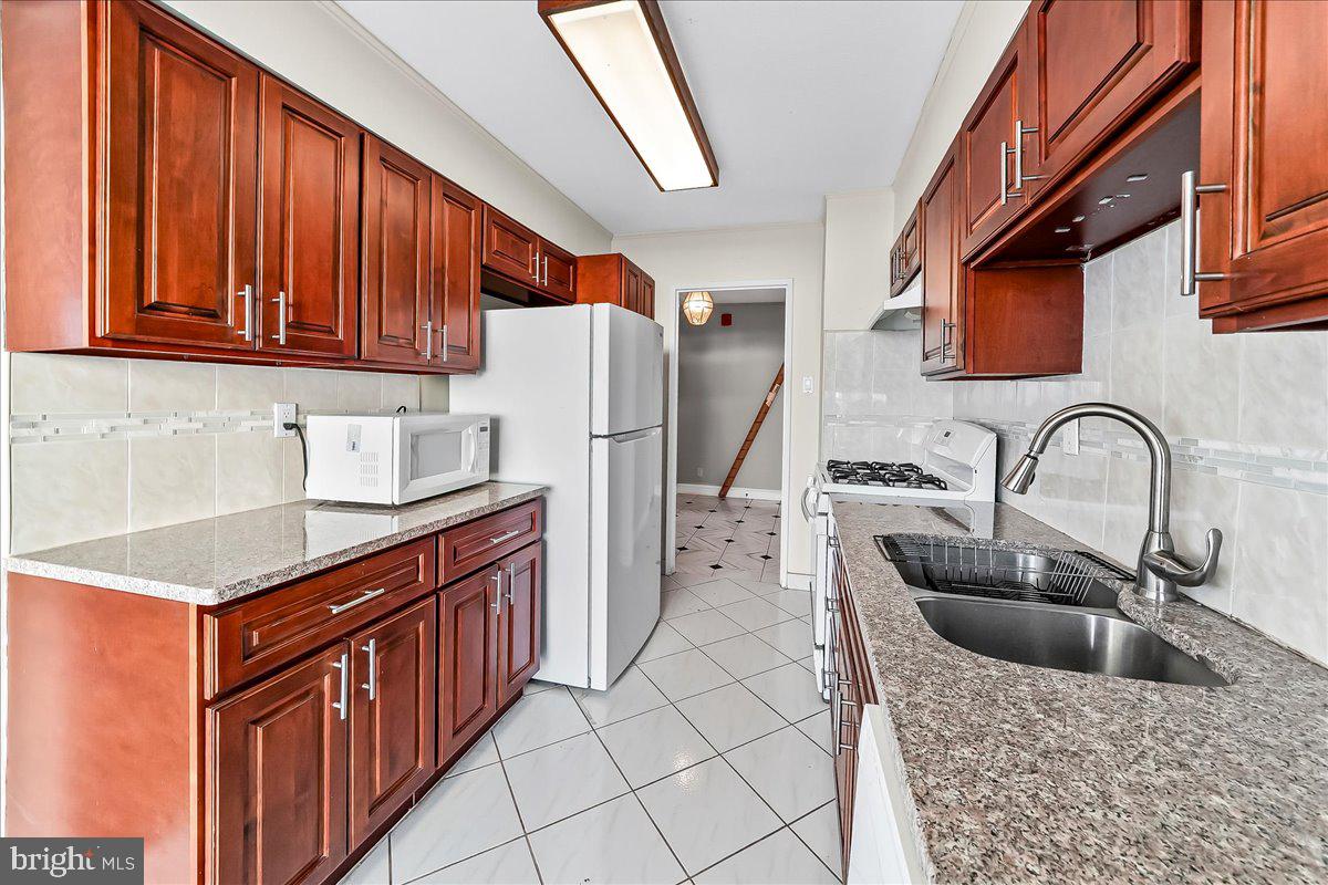 3900 West Ford Road, Unit 17P Philadelphia, PA 19131 - Photo 12 of 28 a kitchen with stainless steel appliances granite countertop a sink and a refrigerator