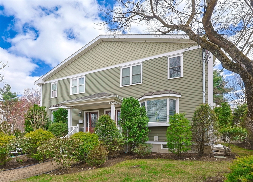 98-100 Lexington Street, Unit 100 Newton, MA 02466 - Photo 1 of 42 a front view of a house with a yard and a garage