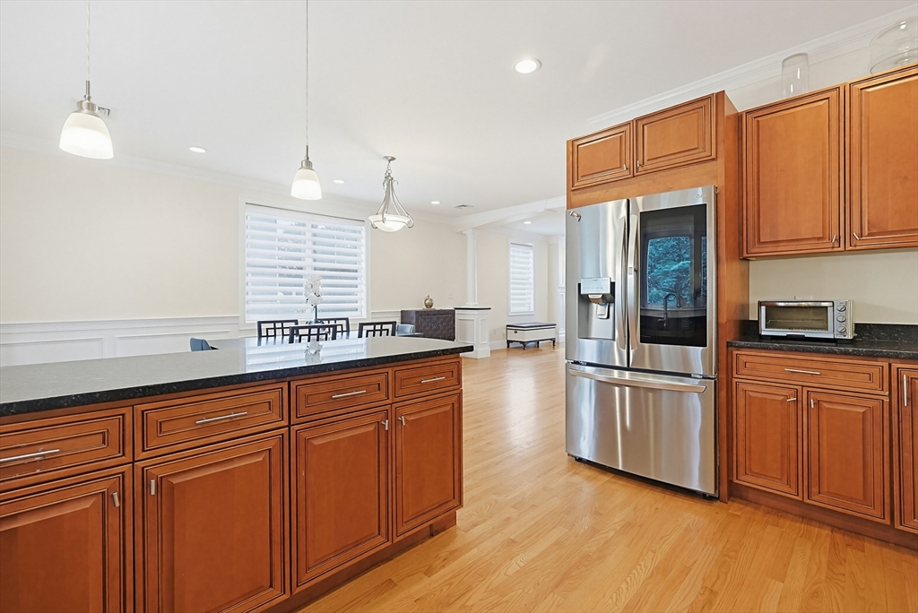 98-100 Lexington Street, Unit 100 Newton, MA 02466 - Photo 12 of 42 a kitchen with stainless steel appliances granite countertop a refrigerator a sink dishwasher and white cabinets with wooden floor