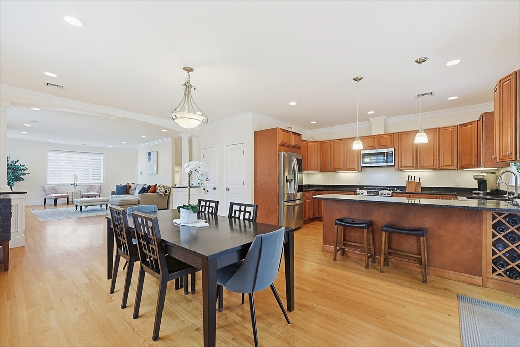 98-100 Lexington Street, Unit 100 Newton, MA 02466 - Photo 13 of 42 a kitchen with a dining table chairs wooden floor appliances and cabinets