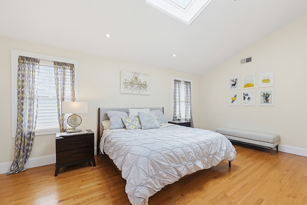 98-100 Lexington Street, Unit 100 Newton, MA 02466 - Photo 21 of 42 a bedroom with a bed and wooden floor