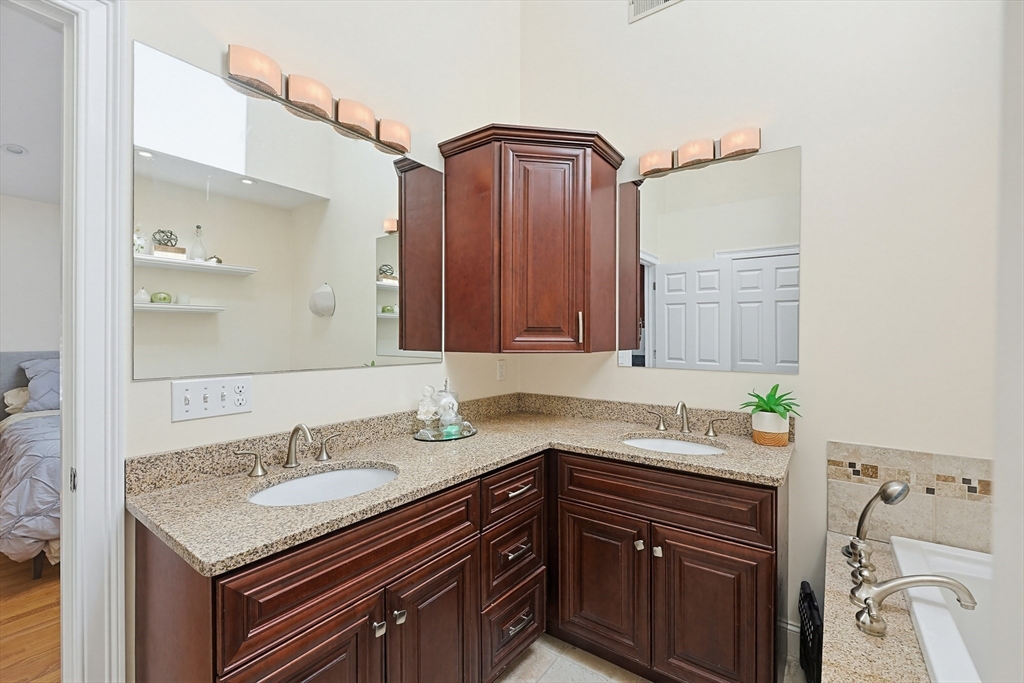 98-100 Lexington Street, Unit 100 Newton, MA 02466 - Photo 22 of 42 a bathroom with a granite countertop sink and a mirror