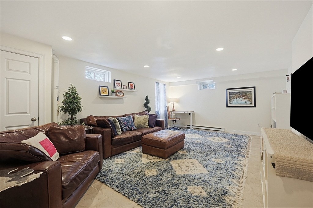 98-100 Lexington Street, Unit 100 Newton, MA 02466 - Photo 32 of 42 a living room with a couch and a flat screen tv