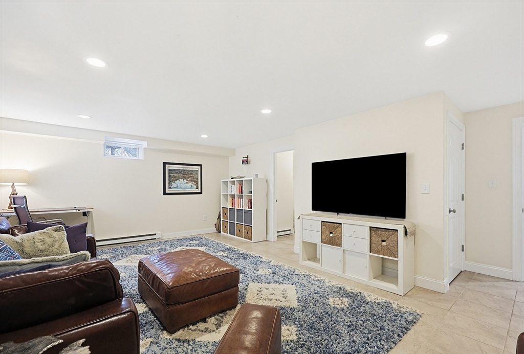 98-100 Lexington Street, Unit 100 Newton, MA 02466 - Photo 33 of 42 a living room with a couch and a flat screen tv