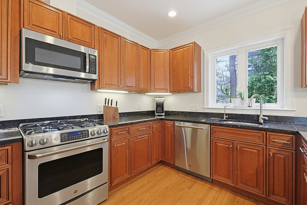 98-100 Lexington Street, Unit 100 Newton, MA 02466 - Photo 8 of 42 a kitchen with granite countertop wooden cabinets stainless steel appliances and a window
