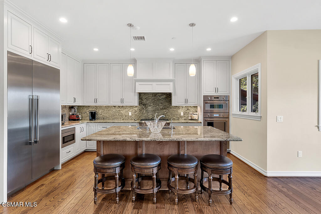 1153 Camino Dos Rios Thousand Oaks, CA 91360 - Photo 16 of 71 a large kitchen with dining table stainless steel appliances and wooden floor