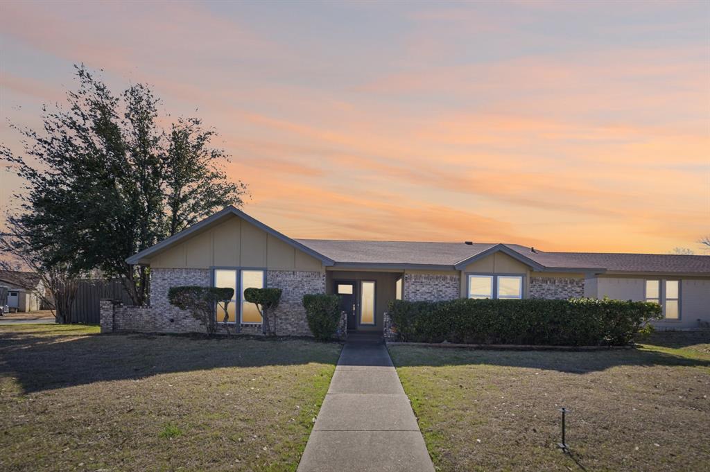 a front view of a house with yard and parking