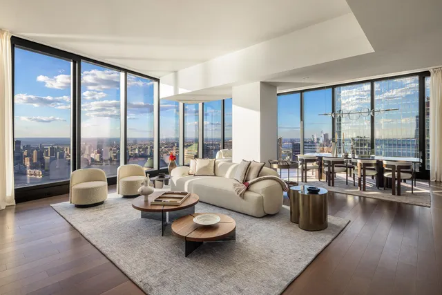 a living room with furniture and floor to ceiling windows