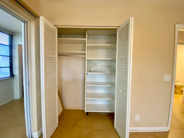 a view of walk in closet with empty racks