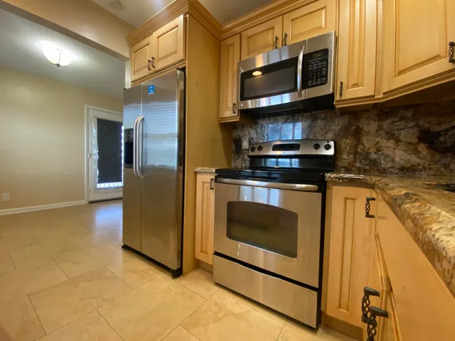 a kitchen with stainless steel appliances granite countertop a stove a microwave and a sink