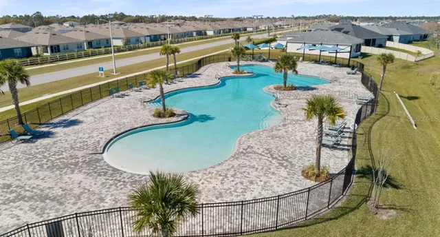 an aerial view of a swimming pool with a yard and mountain view