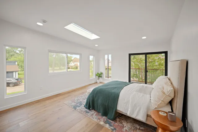 a bed sitting in a spacious bedroom next to a window