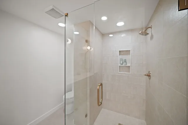 a bathroom with a shower and a glass door
