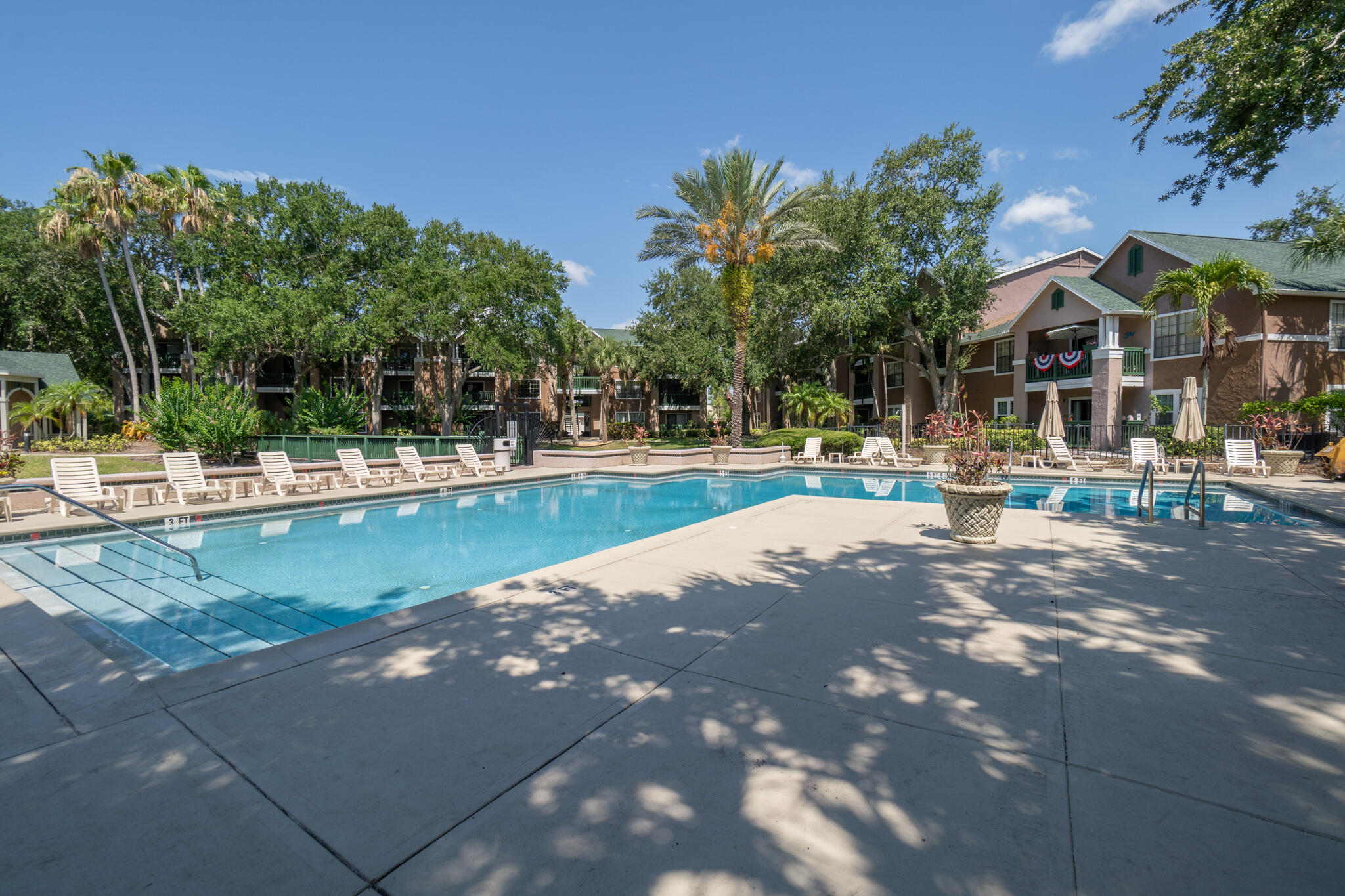 7667 North Wickham Road, Unit 511 Melbourne, FL 32940 - Photo 15 of 48 a view of pool with outdoor seating and trees in the background