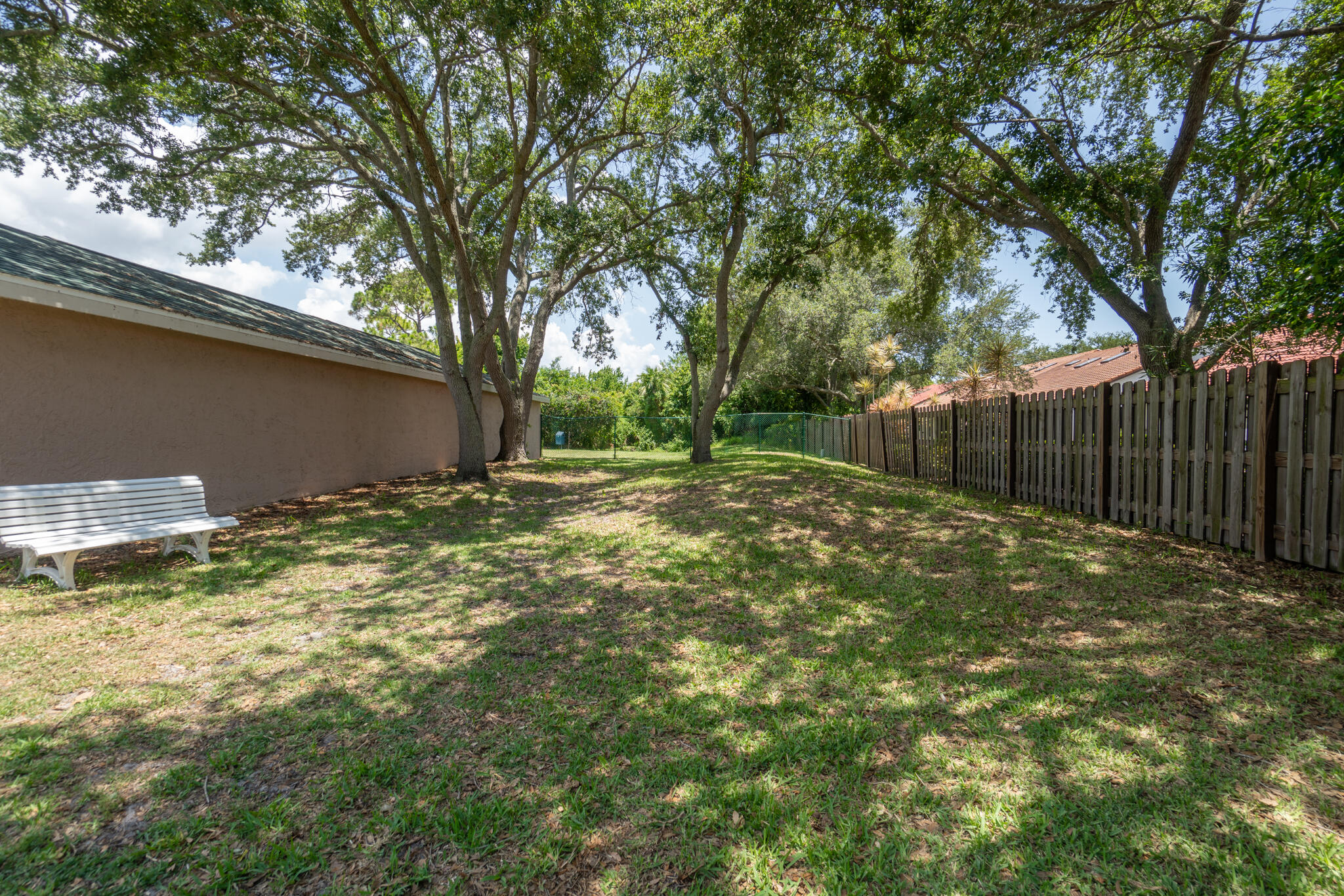 7667 North Wickham Road, Unit 511 Melbourne, FL 32940 - Photo 34 of 48 a backyard of a house with lots of plants and large tree