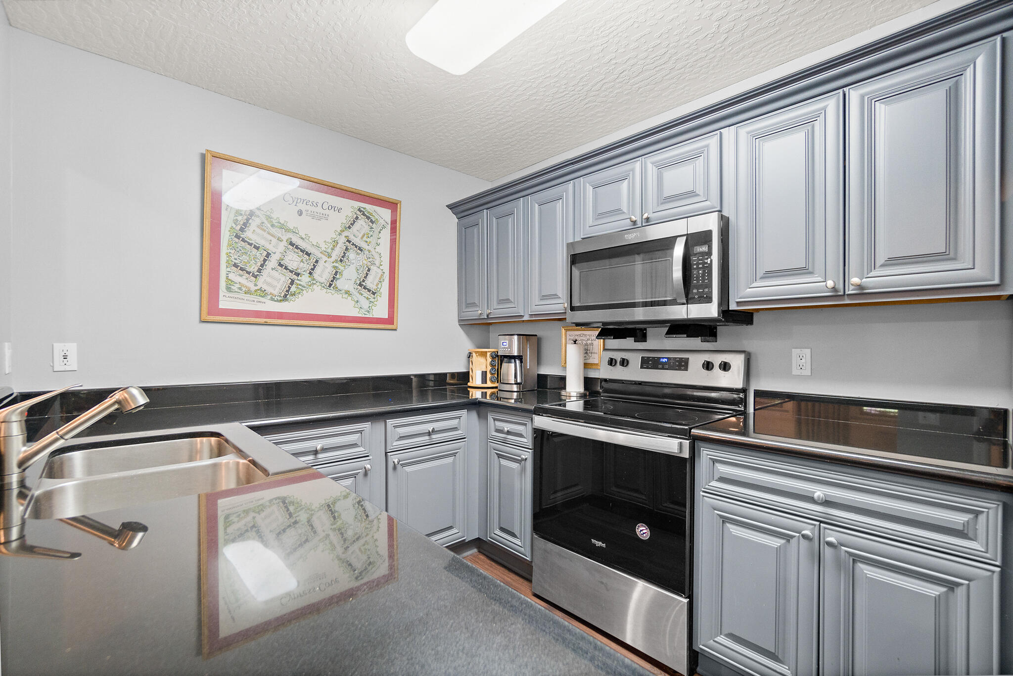 7667 North Wickham Road, Unit 511 Melbourne, FL 32940 - Photo 43 of 48 a kitchen with stainless steel appliances granite countertop a stove and a microwave