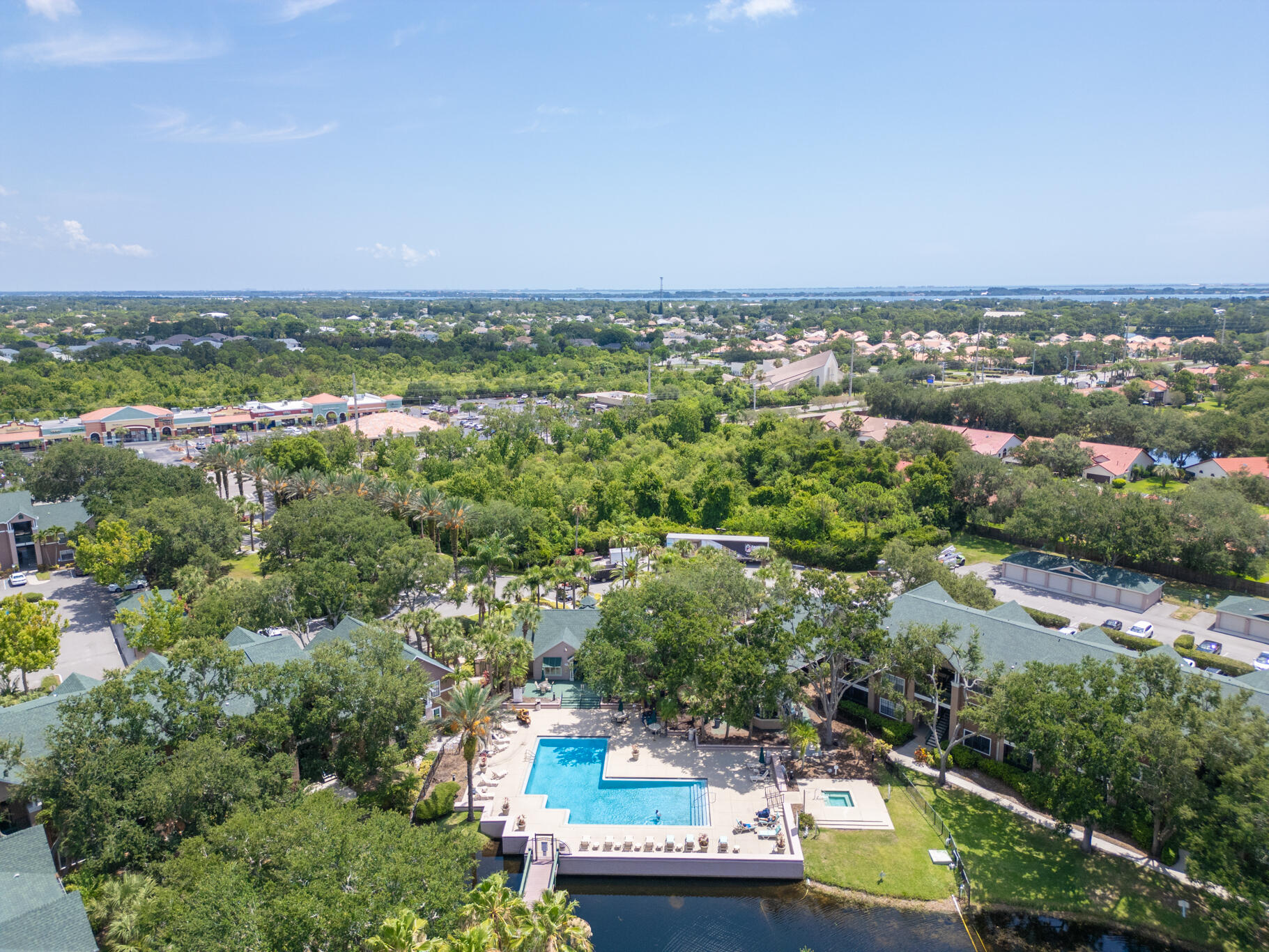 7667 North Wickham Road, Unit 511 Melbourne, FL 32940 - Photo 47 of 48 an aerial view of residential houses with outdoor space and trees