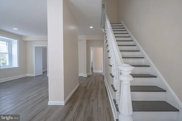 a view of a hallway with wooden floor and entryway