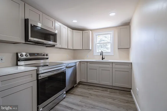 a kitchen with stainless steel appliances granite countertop a sink a stove a microwave and cabinets