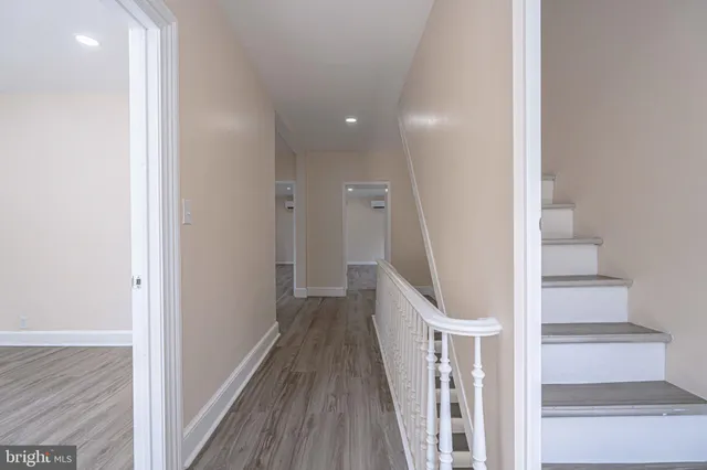 a view of a hallway with wooden floor and staircase