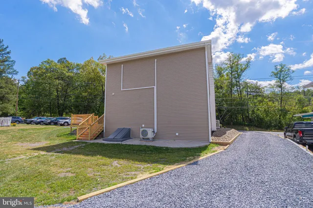 a view of a backyard with potted plants and large trees