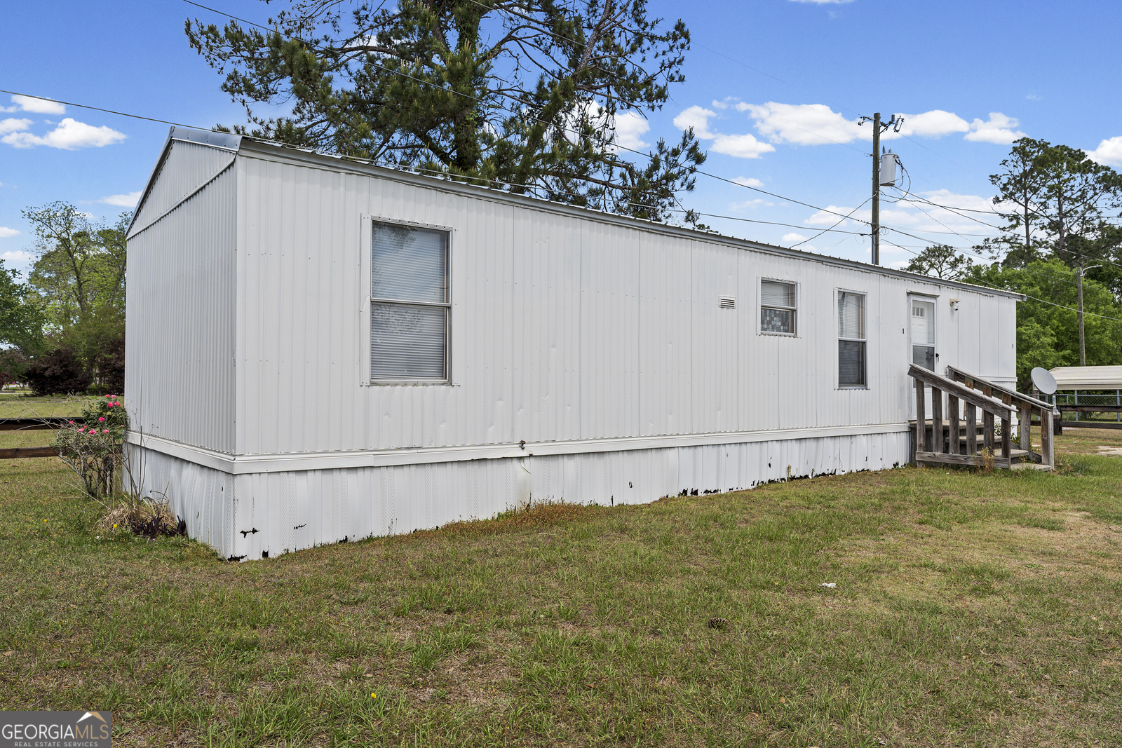 227 Bell Telephone Road Hazlehurst, GA 31539 - Photo 6 of 20 a white house with tree in the background