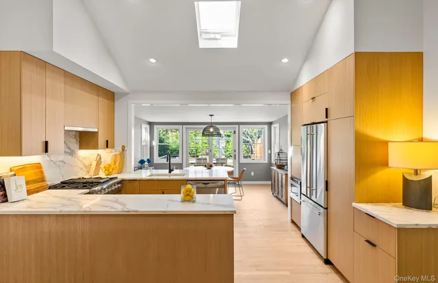 a living room with stainless steel appliances granite countertop furniture and a large window