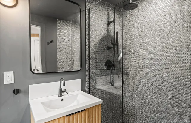 a bathroom with a sink a mirror and shower