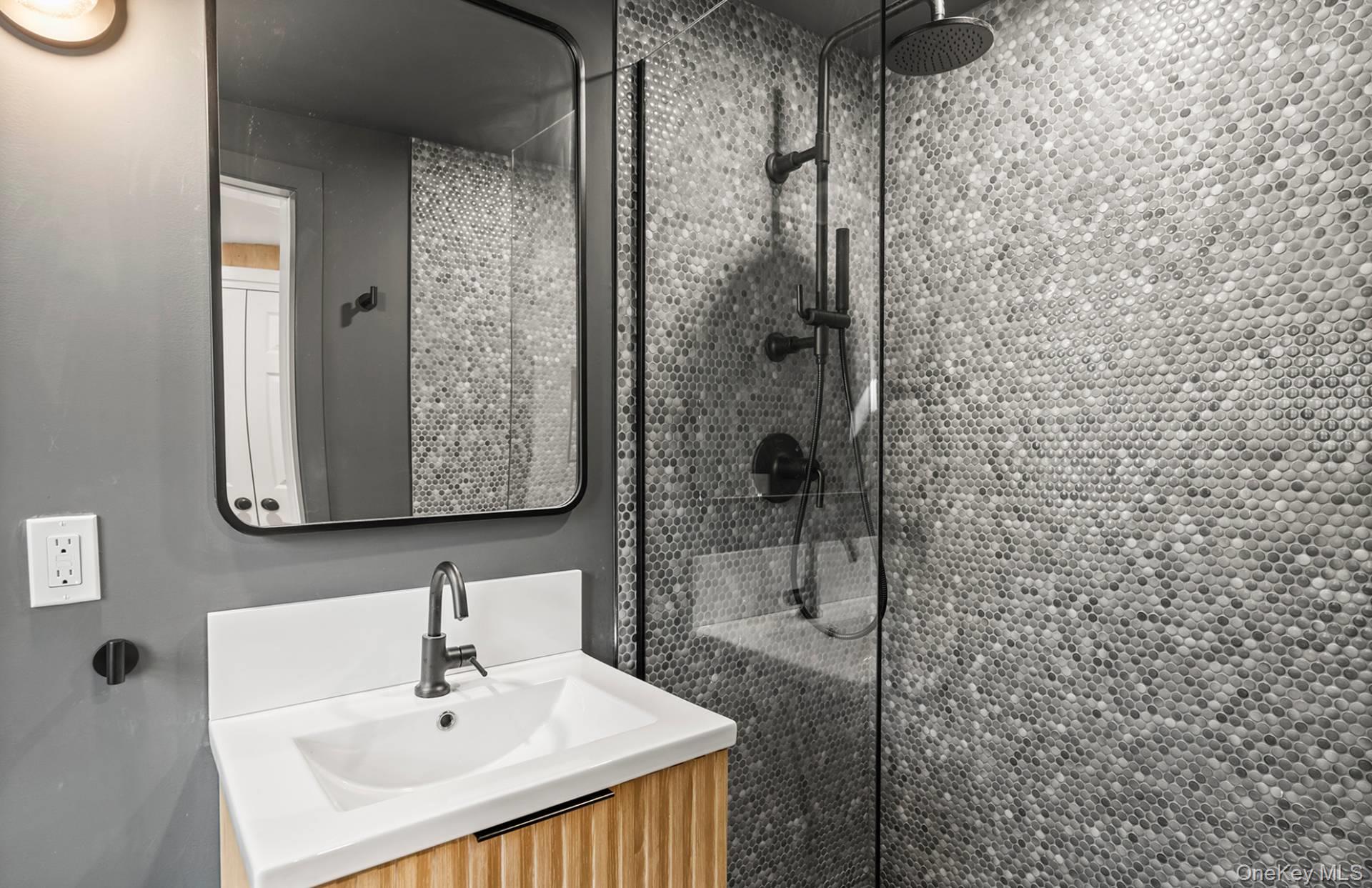 7 Sims Avenue Sag Harbor, NY 11963 - Photo 25 of 30 a bathroom with a sink a mirror and shower