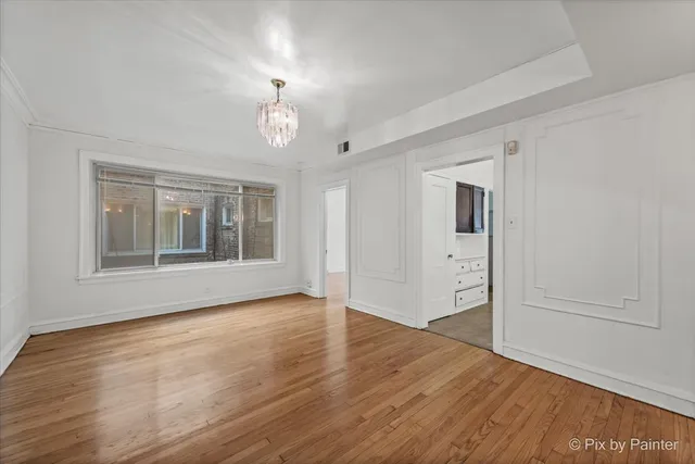 a view of an empty room with cabinet and mirrors