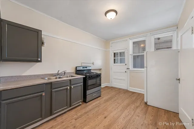 an empty room with wooden floor mirror and windows