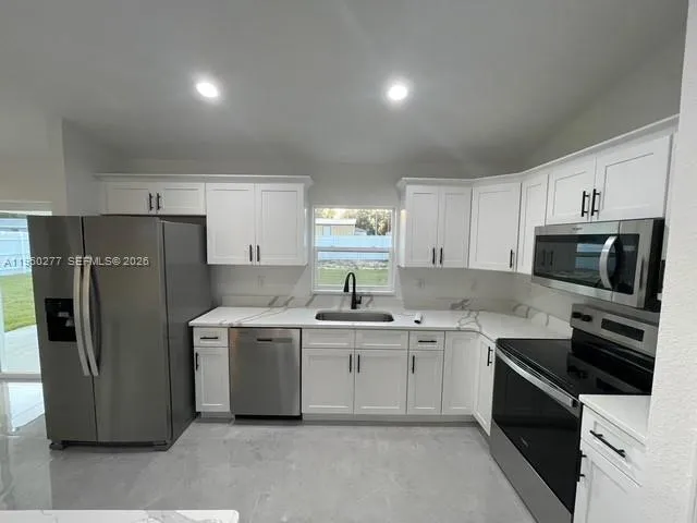 a kitchen with a sink stove and refrigerator