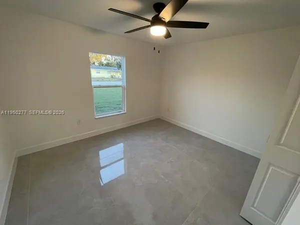 an empty room with windows and fan