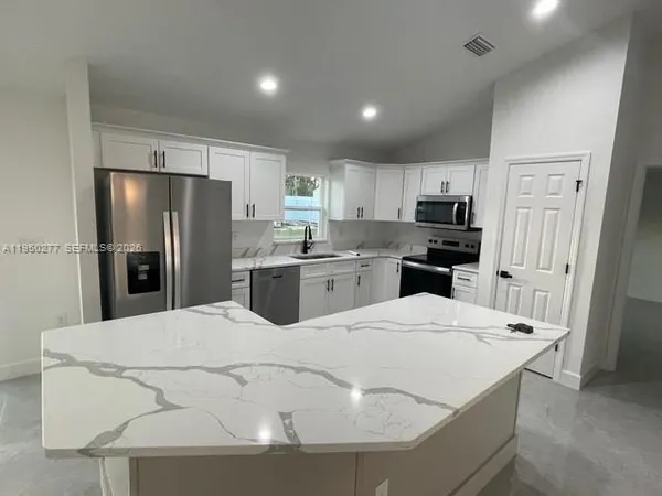 a kitchen with stainless steel appliances a refrigerator sink and microwave