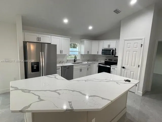 a kitchen with stainless steel appliances a refrigerator sink and microwave