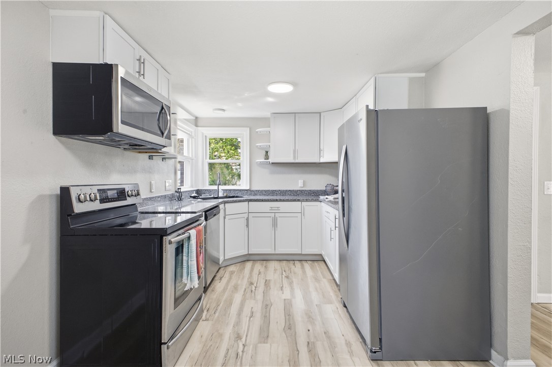 3232 Bears Den Road Youngstown, OH 44511 - Photo 5 of 38 Kitchen featuring white cabinetry, dark speckled countertops, stainless steel appliances, wood-finish flooring, and recessed lighting