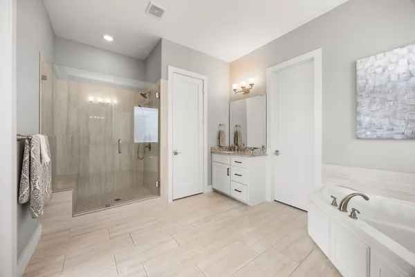a bathroom with a tub a sink and shower