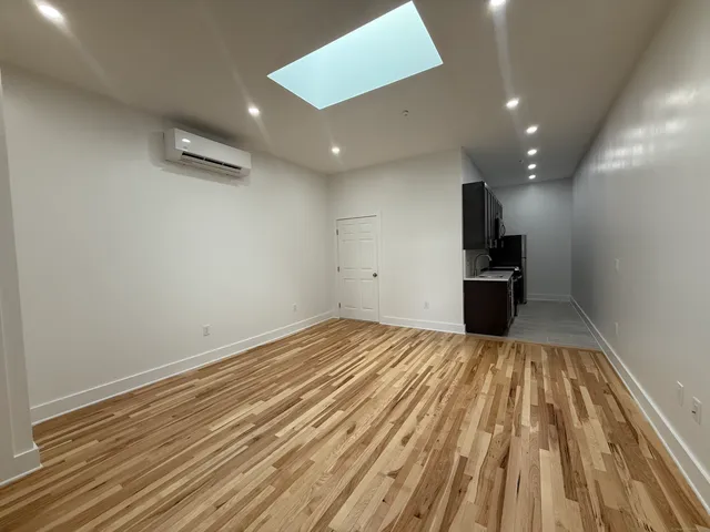 a view of empty room with wooden floor