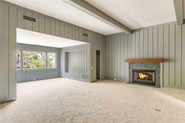 a view of an empty room with a fireplace and a window