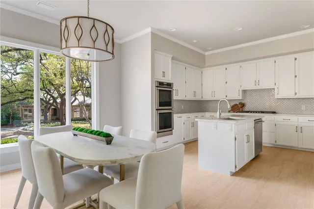 a kitchen with granite countertop white cabinets and stainless steel appliances