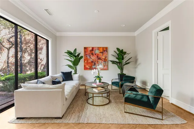 a living room with furniture potted plant a large window and a potted plant