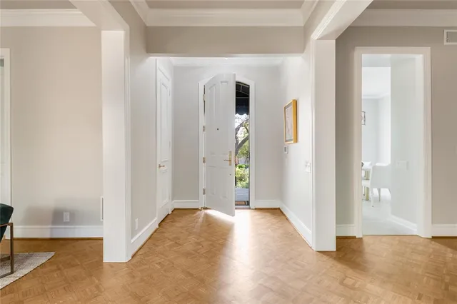 a view of a hallway with wooden floor and a livingroom