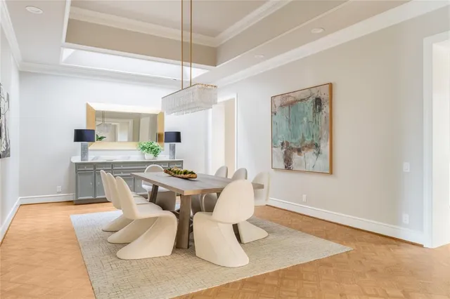 a dining room with wooden floor and white walls
