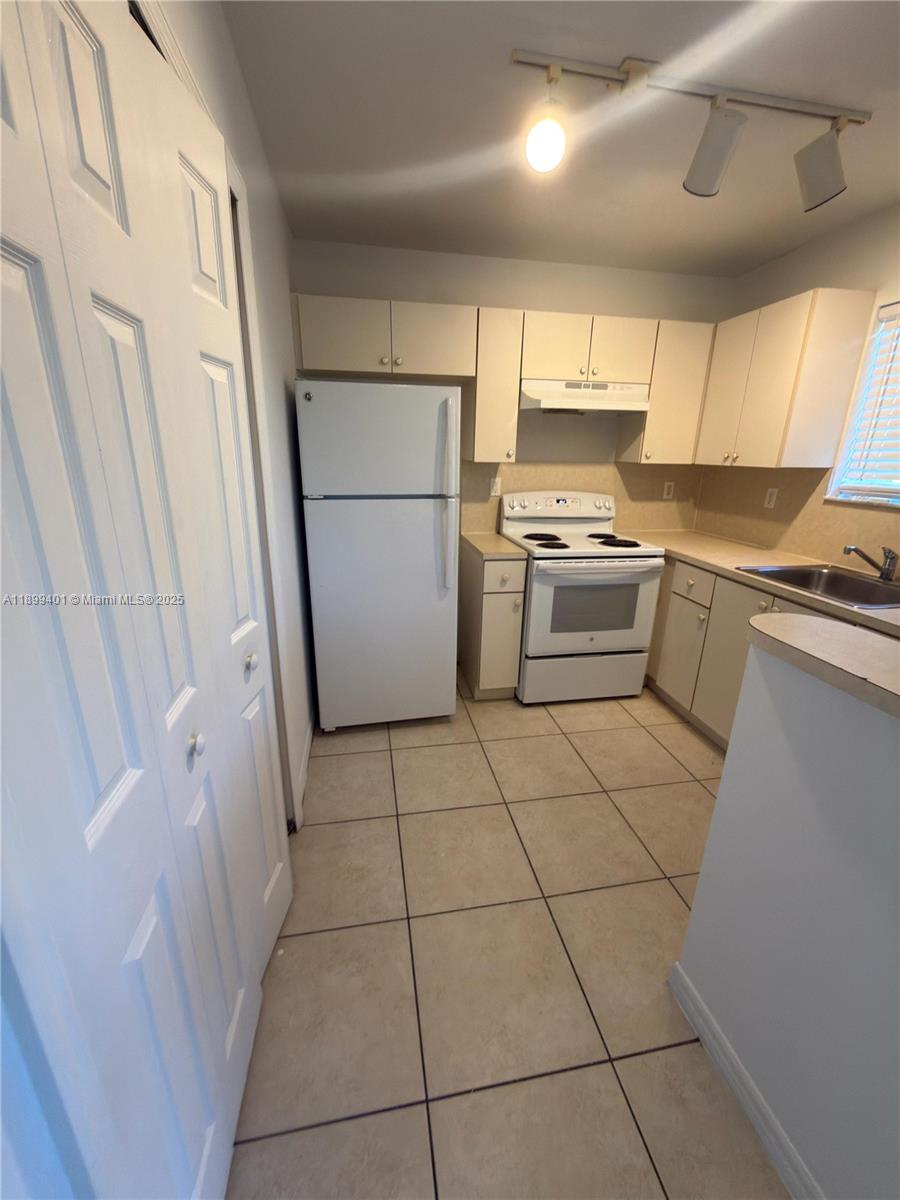 930 Northeast 34th Avenue, Unit 201 Homestead, FL 33033 - Photo 13 of 26 a kitchen with a stove a refrigerator a sink and dishwasher