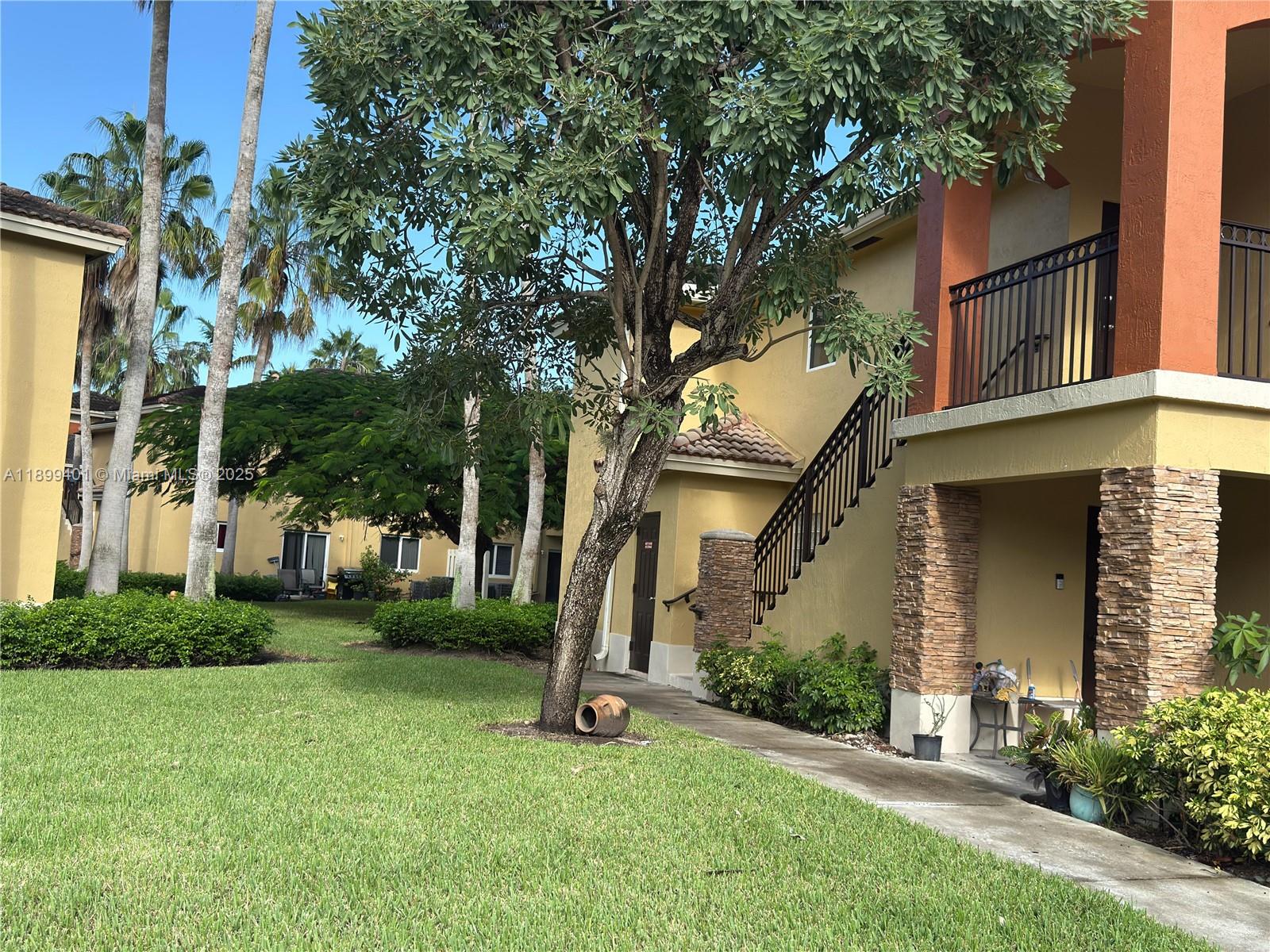 930 Northeast 34th Avenue, Unit 201 Homestead, FL 33033 - Photo 2 of 26 front view of a house with a yard