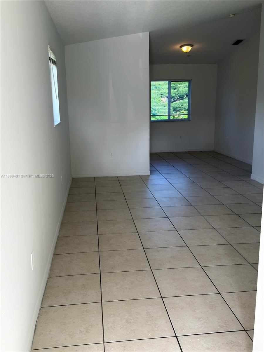 930 Northeast 34th Avenue, Unit 201 Homestead, FL 33033 - Photo 5 of 26 an empty room with windows