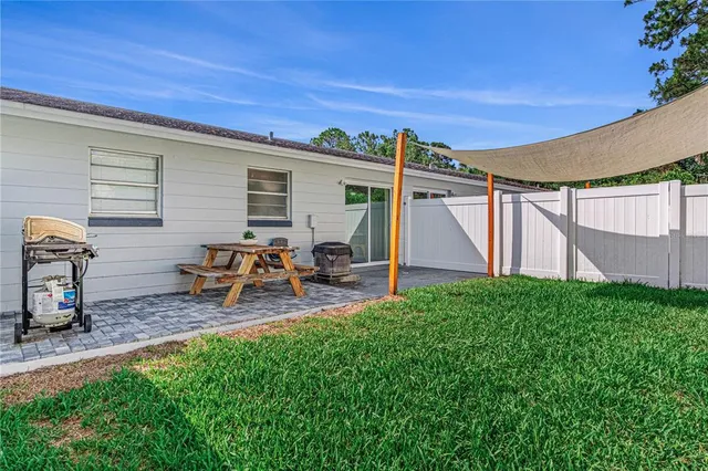 a view of a backyard with table and chairs and potted plants